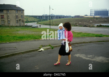 Povertà 1980s Blackhills estate Glasgow. La madre e il suo bambino sono trasportati. Scozia anni '80 Regno Unito HOMER SYKES Foto Stock