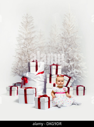 Adorable baby su alberi di natale Foto Stock