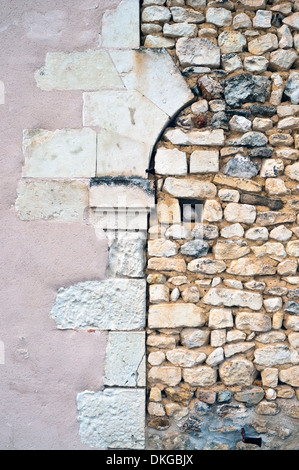 Il vecchio portale ad arco riempiti con random muro di pietra - Francia. Foto Stock