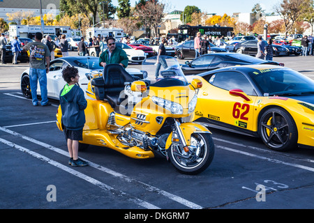 Un custom tre moto ruota accanto a una Ferrari race car Foto Stock