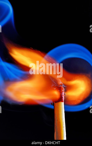 Fiammifero bruciato con fumo blu su sfondo nero Foto Stock