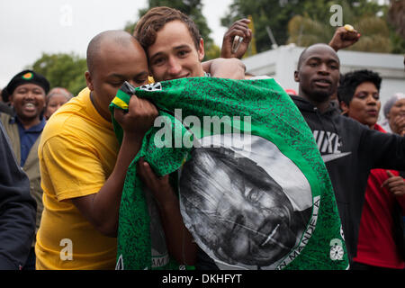 Houghton, Sud Africa. Il 6 dicembre 2013. Sandile Shangase, uno studente di giurisprudenza presso l'Università di Witwatersrand, sorge con Christopher Strong, allievo presso il St Johns college di commemorare la morte dell ex presidente sudafricano Nelson Mandela al di fuori della sua casa di Houghton, Johannesburg, Sud Africa. Credito: Jay Correia Caboz/Alamy Live News Foto Stock