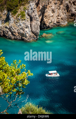 Gite in barca nelle acque blu al largo delle coste del Mar Ionio isola di Corfù, Grecia Foto Stock