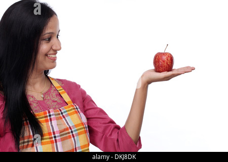 Felice giovane donna azienda red apple contro uno sfondo bianco Foto Stock