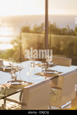 Impostare il tavolo nella sala da pranzo moderna Foto Stock