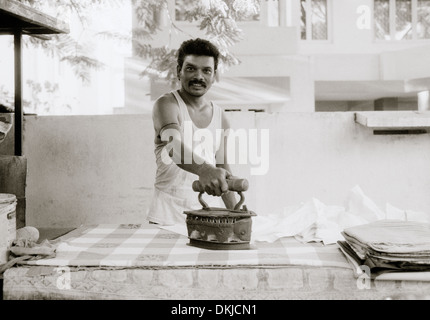 Lavoratore di stiratura in Chennai Madras in Tamil Nadu, nell India orientale in Asia del Sud. Occupazione lavoro professione abiti stile di vita vita ferro Reportage di Viaggio Foto Stock