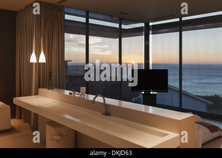 Lavabo moderno in camera da letto con vista oceano al tramonto Foto Stock