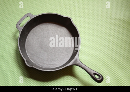 Scrigno padella di ferro su un tappeto verde Foto Stock