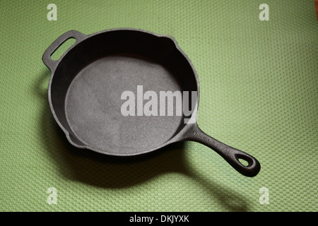 Scrigno padella di ferro su un tappeto verde Foto Stock