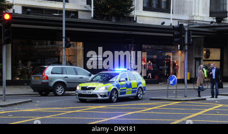 Metropolitan Police auto con luci blu lampeggiante su chiamata di emergenza in Kensington High Street Londra UK Foto Stock