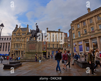 Durham City Centre in un giorno di pioggia. Gli studenti a piedi attraverso il luogo di mercato sul loro modo di classi. Foto Stock