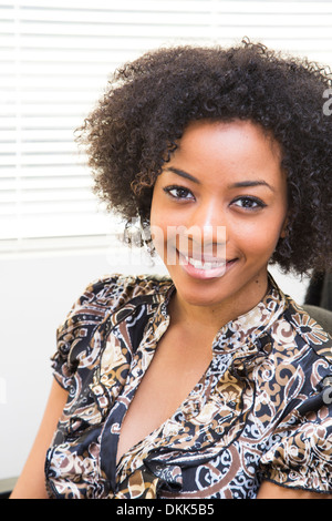 Sorridente giovane americano africano donna che indossa la cuffia Foto Stock