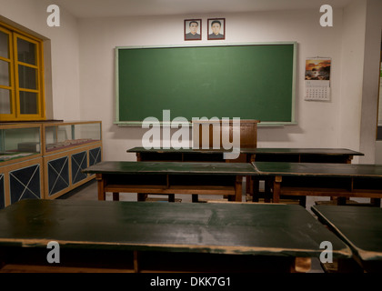Mock-up della Corea del Nord in aula della scuola la visualizzazione di ritratti di Kim Il Sung e Kim Jong Il al di sopra di Blackboard Foto Stock