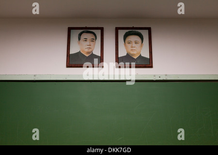 Mock-up della Corea del Nord in aula della scuola la visualizzazione di ritratti di Kim Il Sung e Kim Jong Il al di sopra di Blackboard Foto Stock