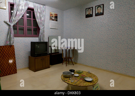 Mock-up del nord coreano casa famiglia interno visualizzazione di ritratti di Kim Il brano e Kim Jong Il sulla parete Foto Stock