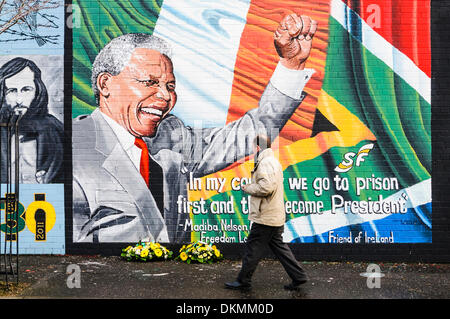 Belfast, Irlanda del Nord. 7 Dic 2013 - Un uomo guarda omaggi floreali a sinistra a Mandela Murale in seguito alla morte di Nelson Mandela il 5 dicembre. Credito: Stephen Barnes/Alamy Live News Foto Stock