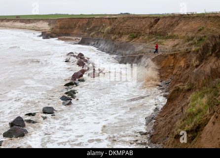 Alta Marea a Happisburgh in Norfolk Inghilterra, con un fotografo a scattare foto dalla spiaggia rampa di accesso Foto Stock