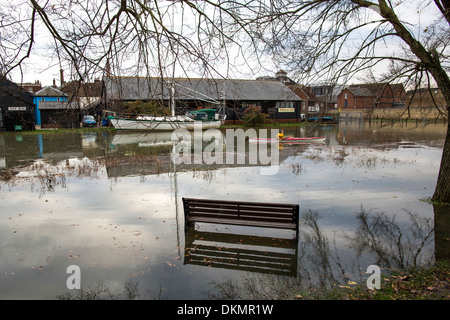 Una sovratensione di marea provoca inondazioni intorno a Faversham Creek. Un banco è parzialmente sommerso dall'alluvione Foto Stock