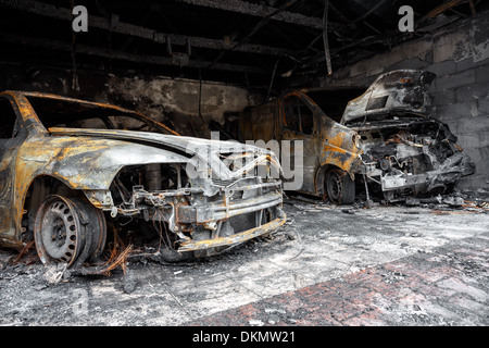 Vicino la foto di un bruciato auto nel garage dopo il fuoco per uso grunge Foto Stock