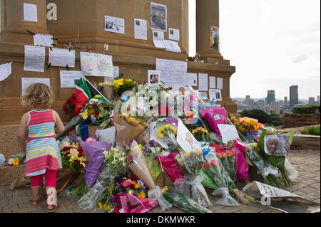 PRETORIA, SUD AFRICA - Sabato 7 dicembre 2013, una bambina cammina tra i numerosi grappoli di fiori durante un momento di lutto nazionale la morte del primo Presidente democraticamente eletto, Nelson Mandela, presso l'Unione edifici di Pretoria, la capitale del Sud Africa. Credito: Roger Sedres/Alamy Live News Foto Stock