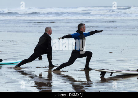 Surfers stretching a Saltburn spiaggia in inverno. Saltburn dal mare, North Yorkshire, Inghilterra, Regno Unito Foto Stock