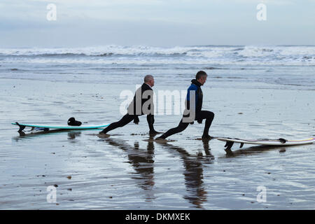 Surfers stretching a Saltburn spiaggia in inverno. Saltburn dal mare, North Yorkshire, Inghilterra, Regno Unito Foto Stock