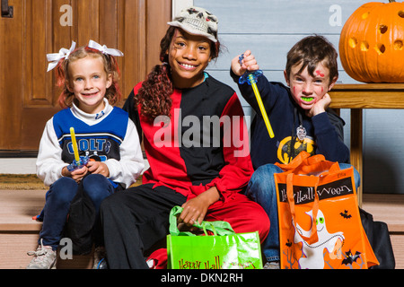 Giovani bambini vestiti in costume per Halloween trucco-o-trattare Foto Stock