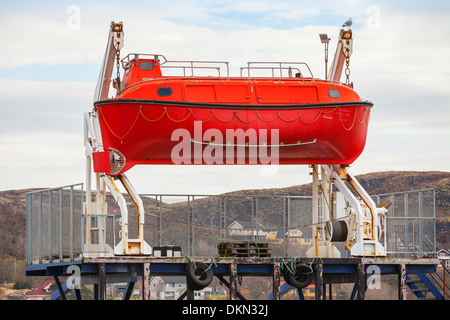 Rosso la barca di salvataggio si erge sulla costa della Norvegia Foto Stock