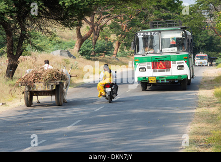 Bus indiano, carrello di giovenco e il motociclo su una strada di campagna. Andhra Pradesh, India Foto Stock