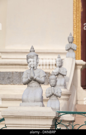 Inginocchiarsi di statue che ornano il Mondapa o Biblioteca Reale, Palazzo reale di Phnom Penh, Cambogia Foto Stock