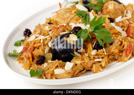 Un autentico Arabia pollo kabsa (noto in Qatar come majbous), guarnita con uvetta e mandorle tostate fiocchi, Foto Stock