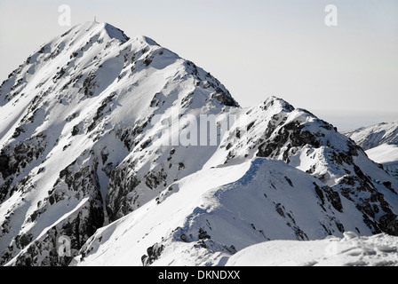 Nevicato montagna cresta con vertice di montagna in background Foto Stock