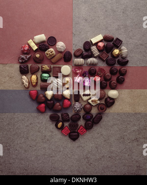 A forma di cuore realizzato a partire da una selezione di sette diverse marche di cioccolatini su uno sfondo di diversi documenti di marmo. Foto Stock