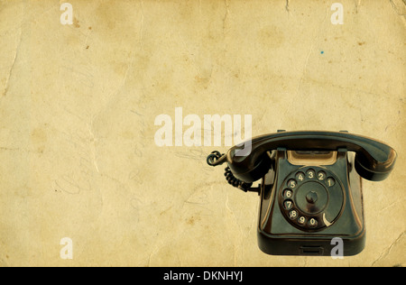 Vecchio telefono nero su sfondo vintage. Isolato su bianco Foto Stock