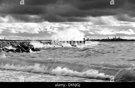 Pontile o molo in una e tempestoso mare turbolento in un cupo ma giornata di sole. La silhouette della città di Tallinn in background. Foto Stock