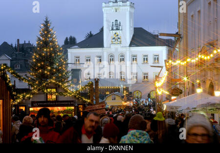Visitatori passeggiata attraverso la luminosa e decorata riccamente mercatino di Natale durante il cosiddetto Lichtelfest (lit. festival delle luci) di fronte al municipio di Schneeberg, Germania, 08 dicembre 2013. Il mercato di Natale e gli eventi collaterali celebrare il Natale tradizionali costumi della montagne Erz durante la regione Lichtelfest. Foto: Hendrik Schmidt/dpa Foto Stock