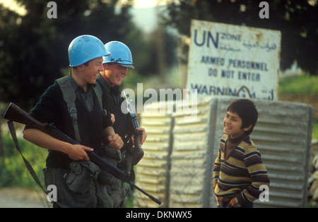 Forze interinali delle Nazioni Unite per il mantenimento della pace UNIFIL in Libano. Un Peace Keepers, il 46° battaglione irlandese con caschi blu tradizionali, due truppe che condividono uno scherzo con un giovane ragazzo libanese. Aprile 1980 1980, HOMER SYKES Foto Stock