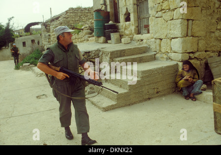 Le truppe irlandesi delle Nazioni Unite nel sud del Libano lavorano attraverso una signora locale di un villaggio di montagna che si tiene lontano mentre i soldati passano davanti. 1980 1980 anni HOMER SYKES Foto Stock