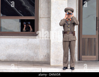 Corea del Nord i soldati guardano verso il giunto Area di sicurezza conosciuto anche come il villaggio di tregua con il binocolo lungo la DMZ Agosto 25, 2007 a Panmunjom, Corea del Sud. Foto Stock