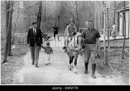 Questa immagine cattura il presidente John F. Kennedy con i suoi figli, John F. Kennedy Jr. E Caroline Kennedy, durante un fine settimana a Camp David, Maryland. La fotografia riflette i momenti personali della famiglia Kennedy e il tempo trascorso dal Presidente lontano dalla Casa Bianca. Foto Stock