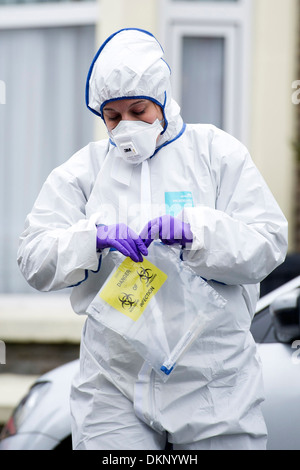 Una scena di polizia di criminalità officer in possesso di una busta di prova nel corso di una polizia investigazione di reati in Cardiff. Foto Stock