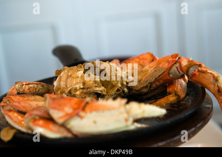 Aglio aroma granchio di Dungeness servita su cook pan Foto Stock