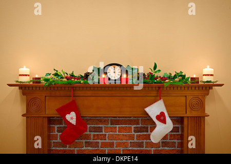 Calze di Natale appesa sopra il camino a mezzanotte della Vigilia di Natale Foto Stock