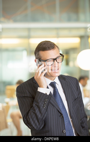 Imprenditore parlando al cellulare in ufficio Foto Stock