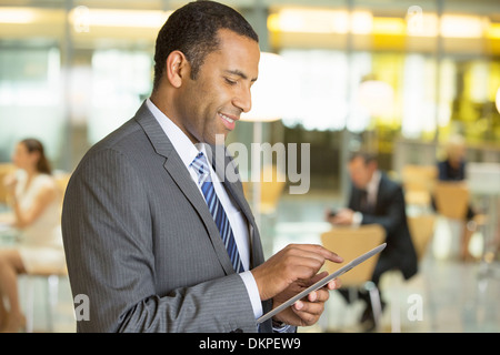 Imprenditore con tavoletta digitale in ufficio Foto Stock