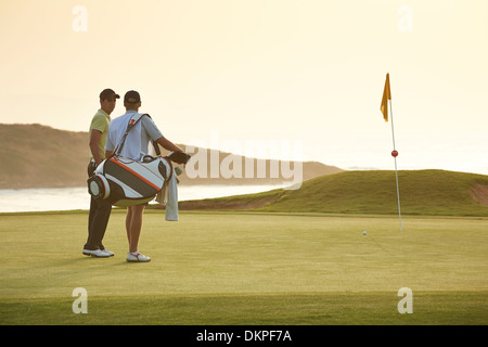 Gli uomini sul campo da golf con vista sull'oceano Foto Stock