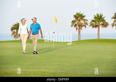 Coppia senior camminando sul campo da golf Foto Stock