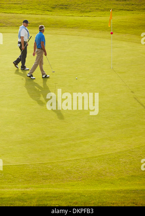 Uomini a piedi alti sul campo da golf Foto Stock