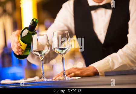 Ben vestito barista versando il vino Foto Stock