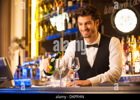 Ben vestito barista versando il vino Foto Stock